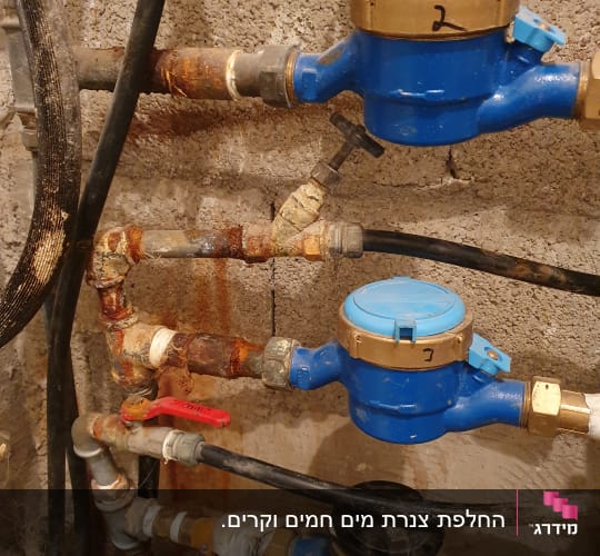 מד מים כחול עם צינורות וברזים חלודים